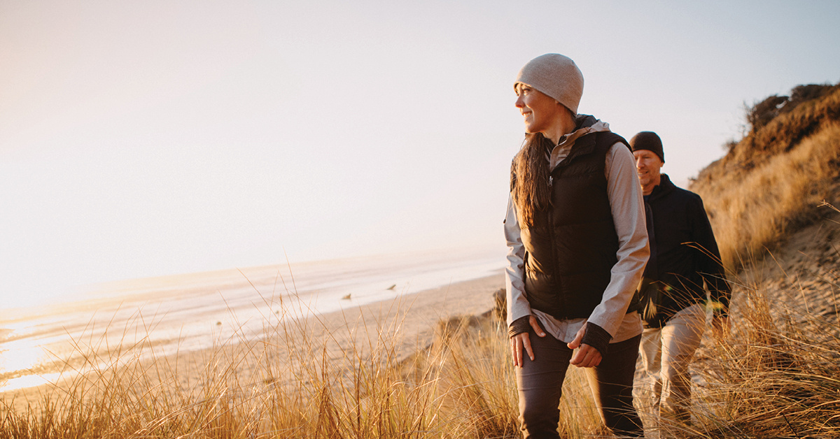 A woman walking along a beach. 